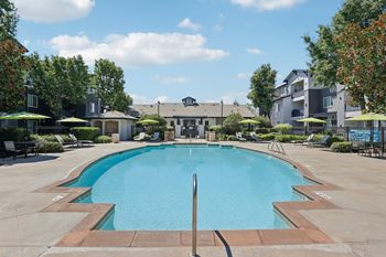 a swimming pool with an apartment building in the background